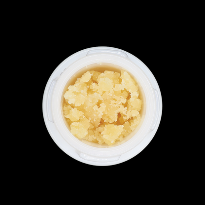 Close-up of Miracle of The Desert Zoap THCa Crumble extract in a glass jar, showing the golden, crumbly resin texture.
