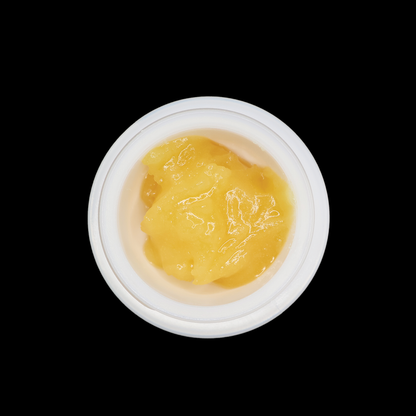 Close-up of Miracle of The Desert Ice Cream Cake THCa Badder in a jar, showcasing its creamy, textured consistency and vibrant color.